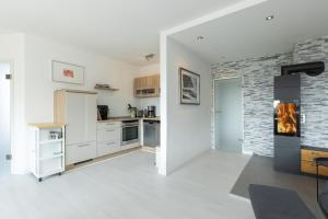 a kitchen with white cabinets and a brick wall at Golfresidenz Wohnung 211 in Grömitz +21 photos