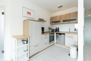 a kitchen with white cabinets and a refrigerator at Golfresidenz Wohnung 211 in Grömitz