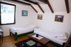 a room with two beds and a table in it at Koliba Ravna planina in Pale