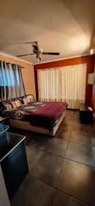 a bedroom with a bed and a ceiling fan at Henning nest guest house in Centurion