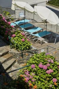 a garden with flowers and umbrellas and a pool at Beachvilla Velden in Velden am Wörthersee