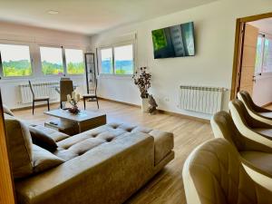 ein Wohnzimmer mit Sofa und Tisch in der Unterkunft Casa La Oveja Negra, con Piscina in Padrenda