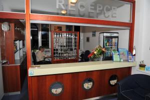 a man is sitting at a bar in a store at Hotel Dakol in Petrovice u Karviné