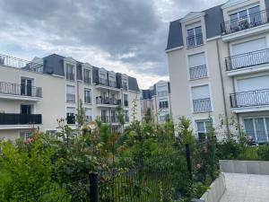 a row of white apartment buildings with flowering plants at Le chic de Villiers Sur Marne in Villiers-sur-Marne