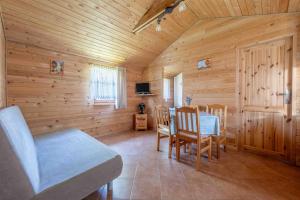 comedor con mesa y sillas en una cabaña en Domki letniskowe Ranczo, en Darłowo