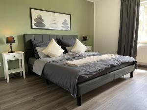 a bedroom with a large bed with two night stands at Moderne Ferienwohnung ab März 2026 mit Saunabereich in Buchet