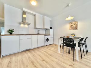 a kitchen with white cabinets and a table and chairs at Sunny Seas Hideaway Apartment in Los Abrigos +25 photos