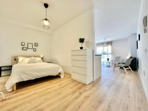 a white bedroom with a bed and a desk at Sunny Seas Hideaway Apartment in Los Abrigos