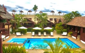 a resort with a swimming pool and chairs and umbrellas at Danieli Resort in Hua Hin
