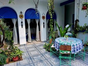 a table and chairs in a room with plants at The Coral House Homestay by the Taj in Agra