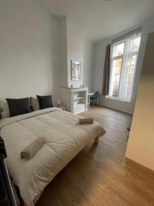 アルマンティエールにあるLa Léonce, superbe appartement plein centreの白いベッドルーム(大型ベッド1台、デスク付)