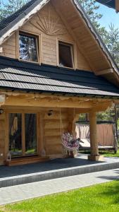a wooden house with a gambrel roof at Ośrodek u Polaka-domek góralski in Radkowice