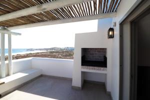 a living room with a fireplace and a view of the ocean at Kestrel Apartments in Paternoster