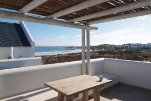 a table on a balcony with a view of the ocean at Kestrel Apartments in Paternoster