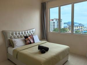 a bedroom with a large bed with a large window at Langkawi Simfoni Platinum Suite in Kuah