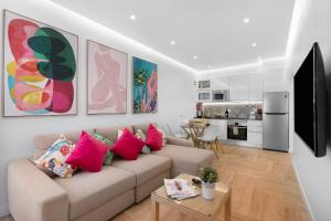 a living room with a couch with pink pillows at Luxury Sweet Homes T2 in Faro +17 photos