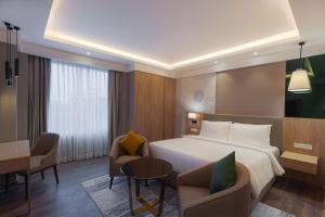 a hotel room with a bed and a table and chairs at Park Inn by Radisson Ayodhya in Ayodhya