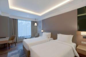 a hotel room with two beds and a desk at Park Inn by Radisson Ayodhya in Ayodhya