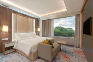 a bedroom with a large bed and a window at Park Inn by Radisson Ayodhya in Ayodhya