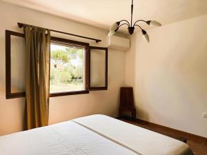 a bedroom with a bed and a window at Marina - Casa de campo cerca de Ciutadella in Cala Blanca
