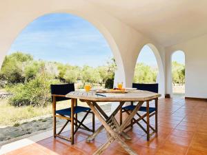 a dining room with a table and two arched windows at Marina - Casa de campo cerca de Ciutadella in Cala Blanca +22 photos