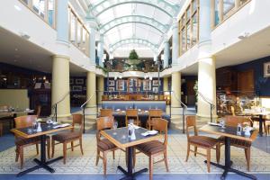 a restaurant with tables and chairs and a glass ceiling at Merton Hotel in St. Saviour