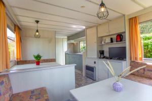 a kitchen with orange curtains and a counter top at Bungalow Sun am See in Zirkow