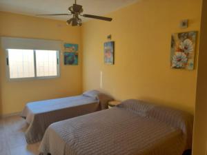 a room with two beds and a ceiling fan at Margarita II in San Fernando del Valle de Catamarca