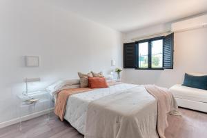 een witte slaapkamer met een bed en een raam bij Casa Tabera - Sun Club Playa del Águila in Playa del Aguila