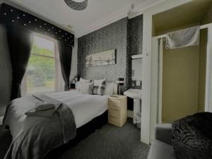 a bedroom with a large bed and a sink at Vaila Guest House in Aberdeen