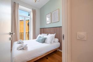 a bedroom with a white bed with a window at Soleil de la Buffa - Un joyau central à 3 min des plages in Nice