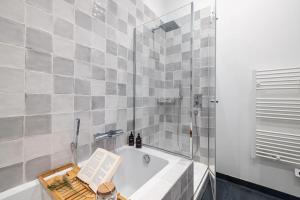 a bathroom with a bath tub with a book on it at Soleil de la Buffa - Un joyau central à 3 min des plages in Nice +19 photos