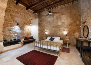 una camera da letto con un letto e un muro di pietra di Napoleon suites a ‘Akko
