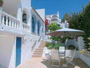 a patio with an umbrella and chairs and stairs at AT Chalet Stella con Piscina Privada in Peniscola