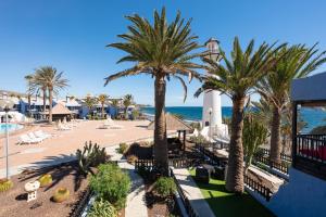 een uitzicht op een resort met palmbomen en de oceaan bij Casa Tabera - Sun Club Playa del Águila in Playa del Aguila