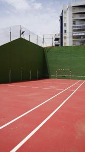 ein Tennisplatz mit einem grünen Zaun darauf in der Unterkunft Apartamento en complejo residencial con piscina in Puebla de Farnals + 23 Fotos