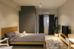 a bedroom with a bed and a television in it at Siesta Spaces Adela in Manila