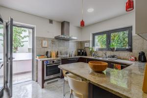 a large kitchen with a counter and a sink at Casa das Fontes - House of Wells in Parede