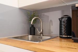 a kitchen sink with a faucet on a counter at Zee homes W6 in London +77 photos
