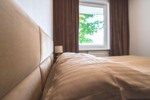 una cama en un dormitorio con ventana en Emila's apartments, en Palanga