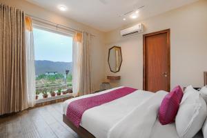 a bedroom with a large bed and a window at SaffronStays Ridgeview Manor, Mukteshwar - 3BHK Villa with Himalayan Views & Verandahs in Mukteshwar