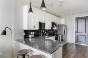 a kitchen with white cabinets and a granite counter top at Blueground Lost Plains parking gym pool wd ATX-261 in Austin