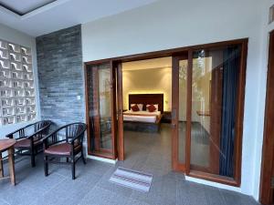 a room with a table and chairs and a bed at Deswa inn in Ubud
