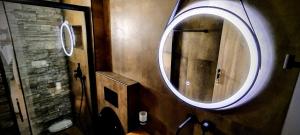a bathroom with a round mirror on the wall at LefkoParga Luxury Suites in Parga +18 photos