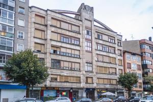 ブルゴスにあるCid Campeador II - Apartamentos Burgos Deluxeの車が停まった古い建物