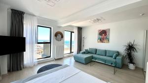 Una sala de estar con un sofá azul y una ventana. en North Club Apartments II, en Mamaia