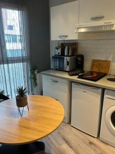 cocina con mesa de madera y encimera en Charmant studio, en Les Lilas