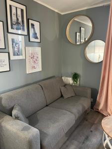 Una sala de estar con un sofá y un espejo. en Charmant studio, en Les Lilas