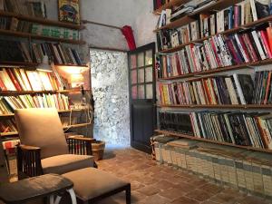 a room filled with shelves filled with books at La Maison Joly in Ménerbes