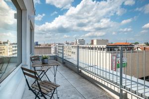 a balcony with a table and chairs and a view of a city at Apartmány Gočárova třída in Hradec Králové